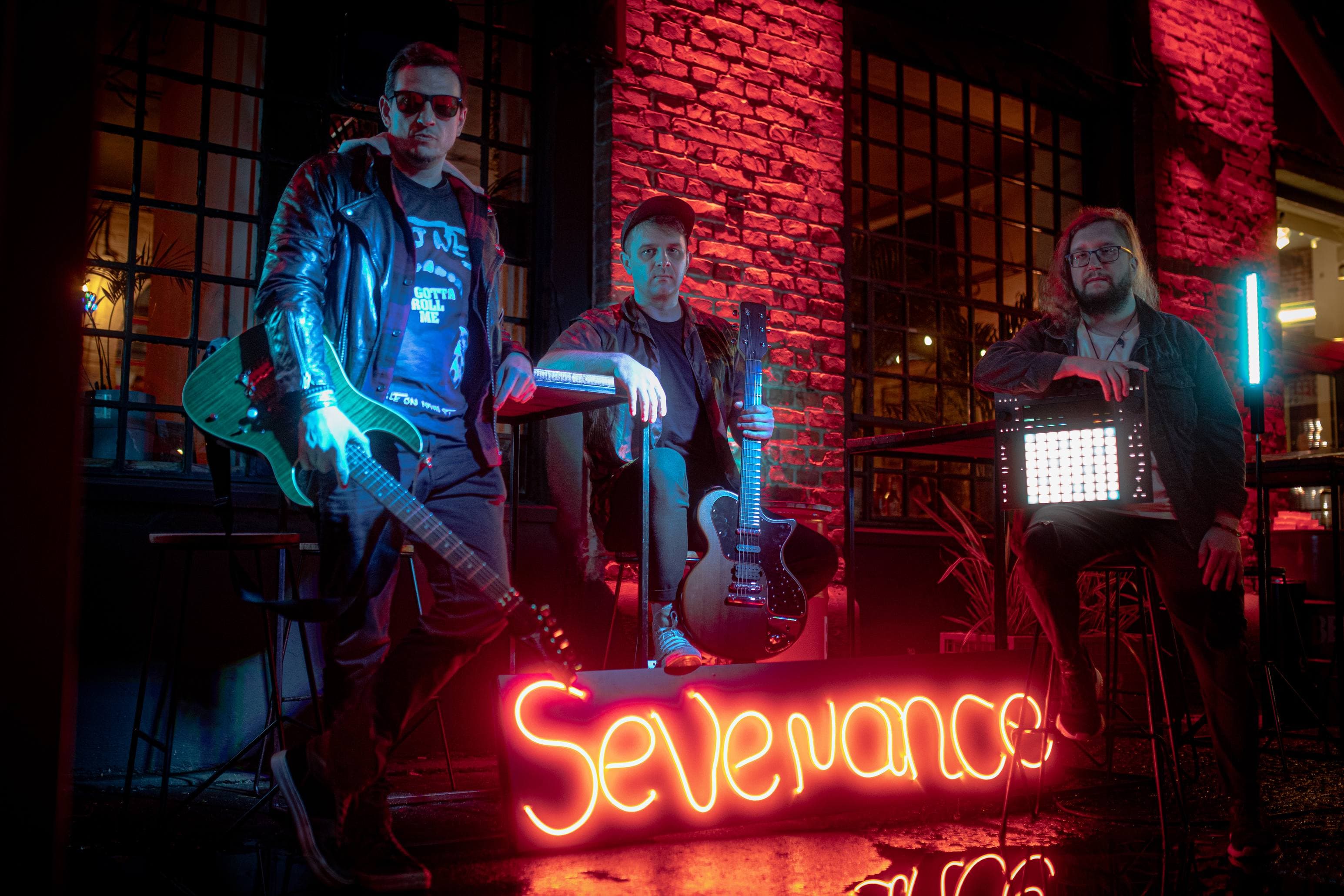 SEVENANCE band with instruments and neon sign